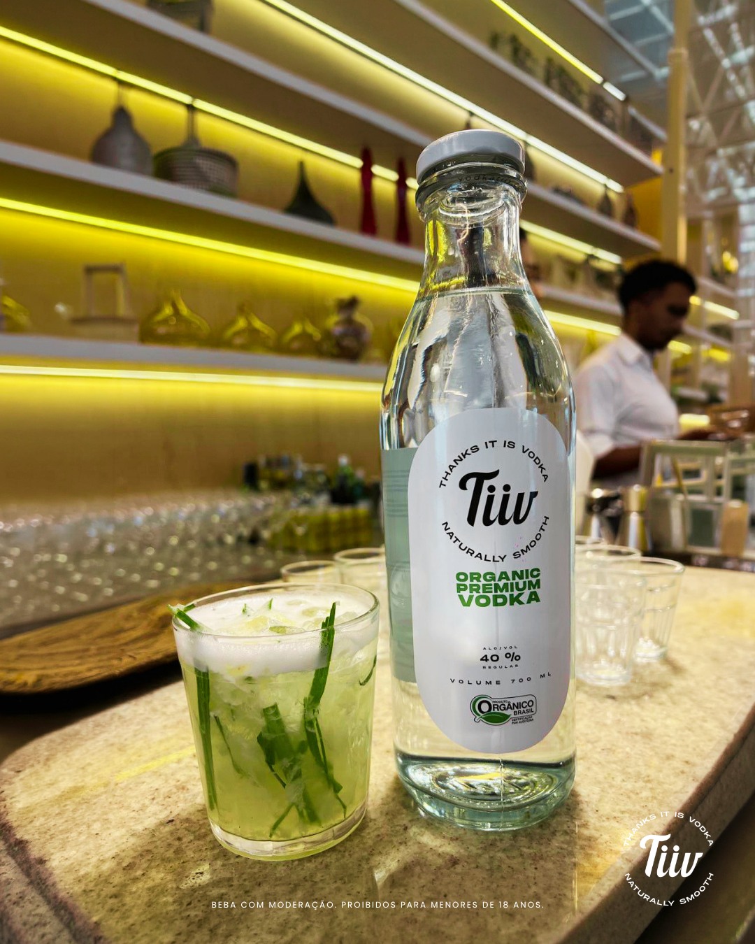 Garrafa e drink Tiiv em fotografia oficial de atmosfera tropical